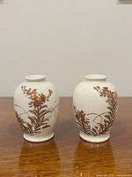 Front view of both Satsuma bud vases showing floral decoration and crackle glaze
