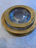 Stacked view of all eight gold-rimmed clear glass dishes