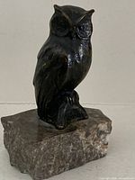 Front view of bronze owl on marble block