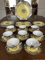 Full layout of tea set showing serving plates, stacked side plates, teacups and saucers