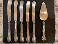Group view of five knives and pie server