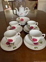 Teapot, four cup-saucer-plate stacks displayed on table