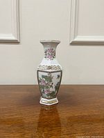 Front view showing floral and bird enamel panel and gilt border