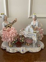 Full view of Dresden lace figurine showing two women, instruments, lace dresses, basket, base