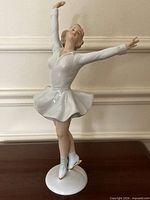 Full view of porcelain ice skater on round base