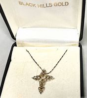 Cross necklace displayed in branded box