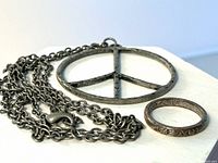 Pendant necklace and ring laid flat showing chain, pendant frame and ring text