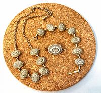 Necklace and bracelet laid out showing complete design and clasp styles