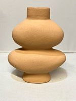 Front view of textured tan ceramic vase