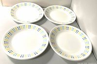 Four of the Corelle plates front view showing rim pattern and size