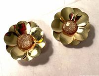 Front view of goldtone flower earrings with glitter centers