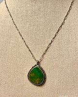 Necklace on display bust showing pendant detail and chain style