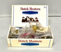 Open cigar box filled with bagged lapel pins