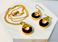 Full view of necklace and both earrings on display