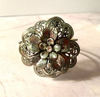 Front view of silvertone flower cuff bracelet showing filigree design