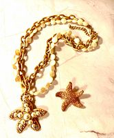 Necklace with pendant, brooch placed beside