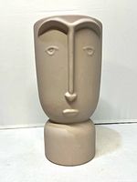 Front view showing stylized face design and pedestal base