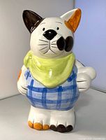 Front view of ceramic cat bank showing colors and attire