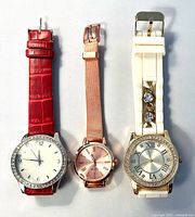 Front view of three watches showing dial designs, strap materials and colors