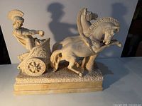 Full view of alabaster-style sculpture showing warrior, chariot, two horses on base