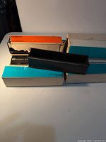 Stack of Argus boxes with one black plastic slide magazine on top