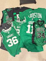 Overview of all jerseys and T-shirts spread on floor showing numbers and colours