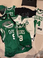 Group shot of four jerseys, black T-shirt visible