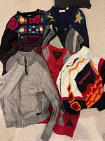 All six sweaters laid out showing styles and colours