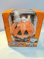 Front view of boxed Snoopy ceramic pumpkin candy dish