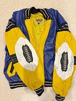 Front view of blue and yellow leather bomber with football motifs