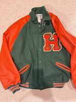 Full front view of green and red-orange varsity jacket