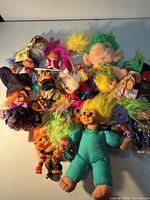 Group shot of entire lot of troll dolls various sizes and colours