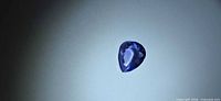 Top view of pear-cut tanzanite on neutral background