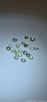 Cluster of 18 lemon-lime tanzanite gemstones on neutral background