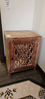 Front angled view of light wood cabinet with lattice mirrored door