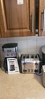 Coffee maker, toaster, and Cuisinart manual on countertop