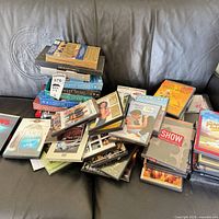 Pile of DVDs and CDs on couch illustrating quantity and mixed media