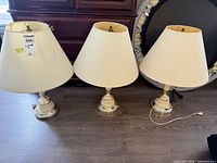 Three matching table lamps with shades on floor