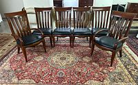 Front view of six Bernhardt wooden dining chairs on rug