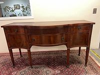 Full view of mahogany sideboard showing drawers, legs, hardware