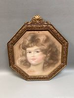 Front view of signed pastel portrait in ornate octagonal gilt frame