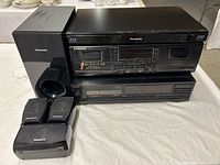 Front view of stacked Panasonic Blu-ray player, Pioneer cassette deck, Sharp CD changer and five Panasonic speakers