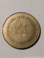 Obverse of brass medallion with Centennial maple leaf and text