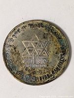 Full view of obverse showing maple leaf triangle design and dates 1867-1967