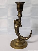 Full view of brass candlestick showing fish-dragon stem and base