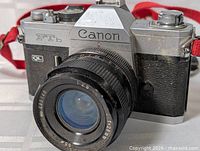Front angle of Canon FTb QL camera with lens and red strap