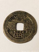 Obverse of round bronze coin with square hole and Chinese characters