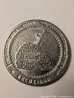 Obverse view showing sword in stone design and date 1990