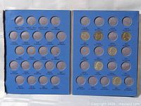 Open album showing both pages with some coins inserted