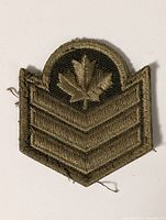 Front view of olive drab Canadian Army rank patch showing three chevrons and maple leaf